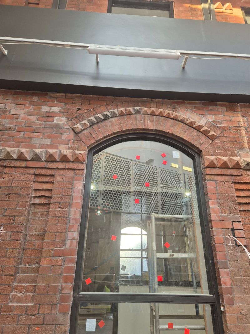 Commercial brickwork repair around an arched shopfront window