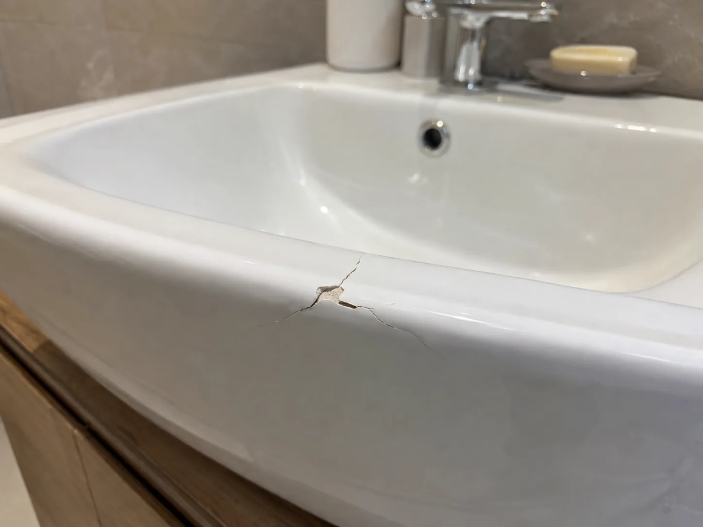 Cracked white ceramic sink requiring cosmetic repair
